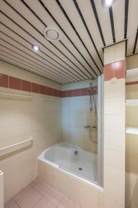 La grande salle de bains est pourvue d'une baignoire et d'une douche. dans l'établissement Vayamundo Oostende - Apartments, à Ostende