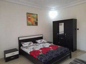 Un dormitorio con una cama con rosas rojas. en CHEZ CODOU MEDINA en Dakar