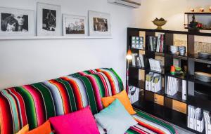 een woonkamer met een bank en kleurrijke kussens bij Awesome Home In Rochefort-du-gard With Kitchen in Rochefort-du-Gard