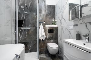 ein Bad mit einer Dusche, einem WC und einem Waschbecken in der Unterkunft Apartamenty Złota by Sun & Snow in Warschau