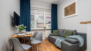 ein Wohnzimmer mit einem Sofa und einem Tisch in der Unterkunft Apartamenty Złota by Sun & Snow in Warschau