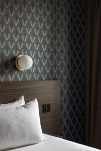 1 dormitorio con 1 cama con pared azul en Kyriad Saint Brieuc - Tregueux, en Tregueux
