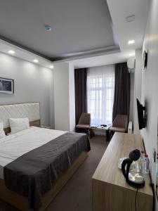 una camera d'albergo con un grande letto e una scrivania di Jupiter a Baku