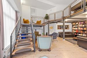a loft apartment with a spiral staircase and a living room at primeflats- Big family apartment Berlin Treptower Park in Berlin