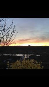 a view of a city with the sunset in the background at Aussichtszimmer mit modernem Glasbad und Balkon in Koblenz