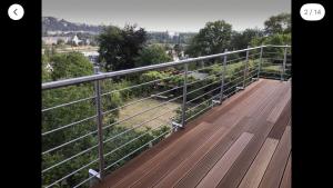 a wooden deck with a railing on top of a hill at Aussichtszimmer mit modernem Glasbad und Balkon in Koblenz