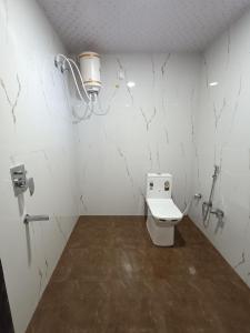 a white bathroom with a toilet in a room at Sal Tree Resort by Vihasta, Kanha in Lagma