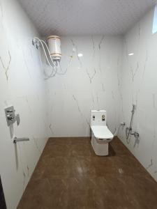 a white bathroom with a toilet in a room at Sal Tree Resort by Vihasta, Kanha in Lagma