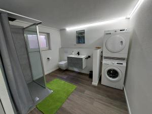 a bathroom with a washing machine and a sink at Titel Am Fuße der Rhön, ist es schön in Bad Kissingen