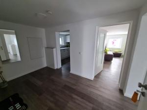 an empty living room with white walls and wood floors at Titel Am Fuße der Rhön, ist es schön in Bad Kissingen