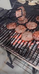 a bunch of hamburgers cooking on a grill at فيلا in Hafr Al-Batin