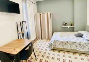 - une chambre avec un lit, une table et un bureau dans l'établissement Studio confort pour 2 Perpignan Bir Hakeim, à Perpignan