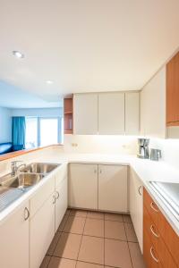 a kitchen with white cabinets and a sink at Vayamundo Oostende - Apartments in Ostend