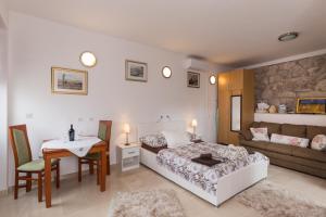 ドゥブロヴニクにあるApartments Diaのベッドルーム1室(ベッド1台、テーブル、ソファ付)