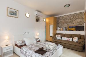 1 dormitorio con 1 cama y 1 sofá en Apartments Dia, en Dubrovnik