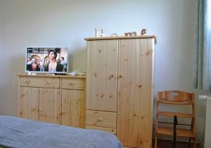 a bedroom with a wooden dresser with a tv on it at Strandläufer - Sünnenkieker WE11 - ABC249 in Beckerwitz