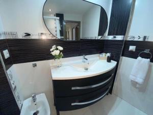 ein Badezimmer mit Waschbecken, Spiegel und Toilette in der Unterkunft Apartamento Soltova in Casar de Cáceres