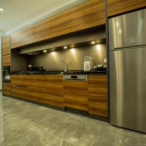 a kitchen with wooden cabinets and a stainless steel refrigerator at Villa Bahamas in Kas