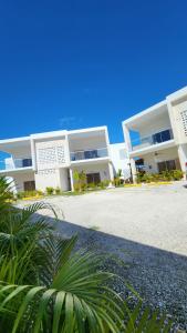 a large white building with a palm tree in front of it at Modern Boho Apt in Punta Cana in Punta Cana