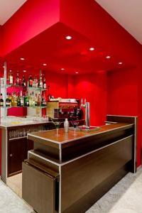 a red kitchen with a bar with red walls at Hôtel Saint Etienne in Lourdes