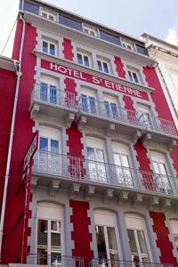 um edifício vermelho com uma placa de hotel em Hôtel Saint Etienne em Lourdes