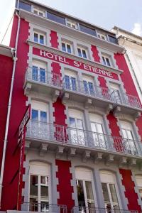 un bâtiment rouge avec un panneau d'hôtel dans l'établissement Hôtel Saint Etienne, à Lourdes