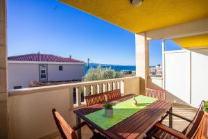 a table and chairs on a balcony with a view at Apartments Tonci in Duće