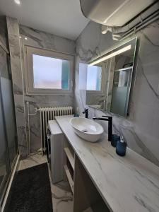 a bathroom with a sink and a mirror at Maison spacieuse jardin Transat - Parking gratuit in Saint-Michel +23 photos
