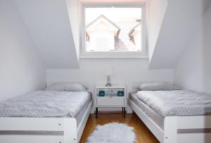 克拉尼的住宿－Apartment in the center of Kranj，带窗户的客房内的两张床