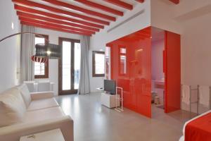 a living room with a white couch and a red wall at Lonja Suites Apartments in Palma de Mallorca
