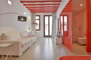 a living room with a white couch and a bathroom at Lonja Suites Apartments in Palma de Mallorca +33 photos