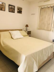 um quarto com uma grande cama branca e uma janela em Appartement Les Asphodèles Calvi em Calvi
