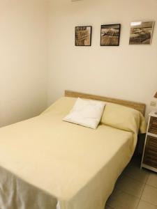 uma cama num quarto com três fotografias na parede em Appartement Les Asphodèles Calvi em Calvi