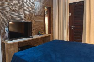 1 dormitorio con TV en un escritorio de madera en Hotel Boutique Zebra Beach, en Uruaú