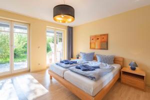 a bedroom with a bed with blue towels on it at Strandhaus Fiete - Haus Poelblick - ABC247 in Hohen Wieschendorf