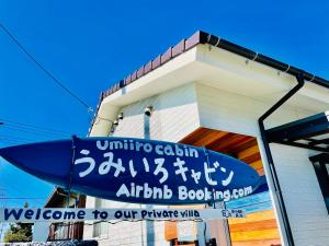 a welcome sign on the side of a building at 町の中心地 星もきれいな貸切宿 "うみいろキャビン " "umiiro cabin" in Ainan