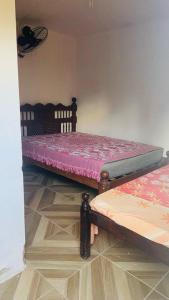 2 Betten in einem Zimmer mit Fußboden in der Unterkunft Chácara Nascimento in Vitória de Santo Antão