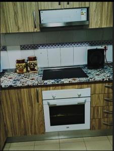 a kitchen with a counter with a stove and a microwave at El MIRADOR DE LA PLAYA in Melilla