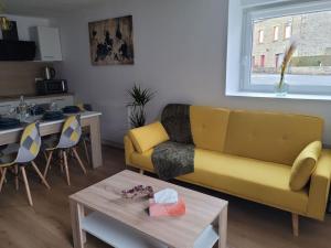 sala de estar con sofá amarillo y mesa en La Parentaise en Mernel