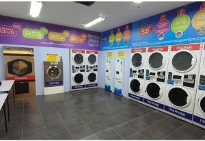 una lavandería con varias lavadoras en la pared en Kozi Square with Infinity Pool I Kuching en Kuching