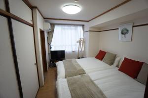 a bedroom with a large white bed and a window at Apartment House Jodo 405 in Osaka
