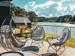 un portico con due sedie e vista sul lago di Celeiro Lake Village - Soft Opening a São Francisco de Paula