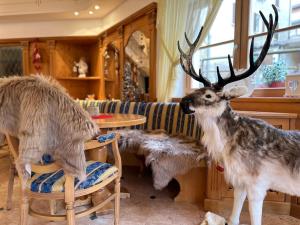 a fake reindeer standing in a living room at Hotel Europa in Molveno