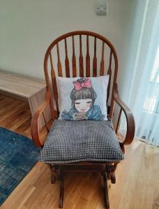 a doll pillow sitting on a wooden rocking chair at Cosy private room in Streatham Hill