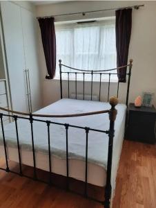 a bedroom with a black bed with a window at Cosy private room in Streatham Hill