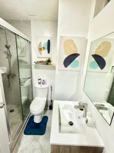 a bathroom with a sink and a toilet and a shower at 119 Amani Grand Mactan Resort in Mactan