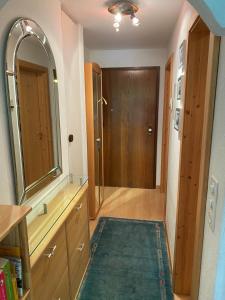 uma casa de banho com um espelho grande e uma porta de madeira em Casa Surselva Wohnung Nr. 5 Marti em Savognin