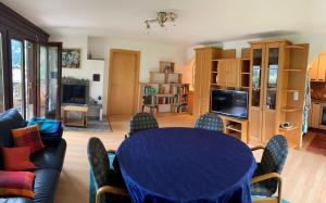 uma sala de estar com uma mesa azul e cadeiras em Casa Surselva Wohnung Nr. 5 Marti em Savognin