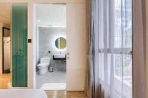 a bathroom with a white toilet and a mirror at MO Hotel Bangkok in Bangkok