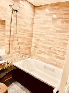 a bathroom with a bath tub and a shower at 町の中心地 星もきれいな貸切宿 "うみいろキャビン " "umiiro cabin" in Ainan